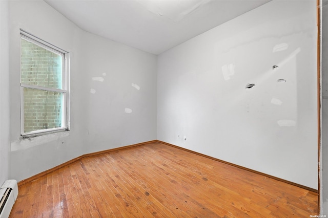 spare room with hardwood / wood-style floors and baseboard heating