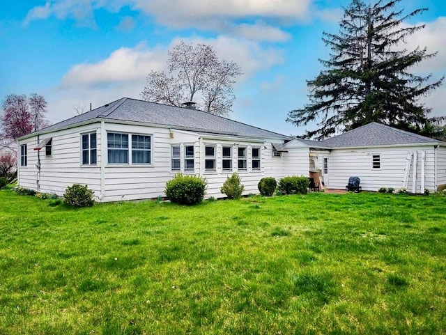 rear view of house with a yard