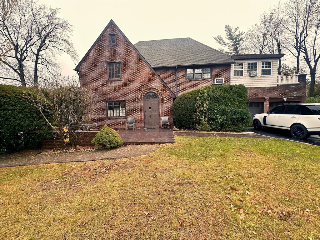 english style home with a garage and a front lawn