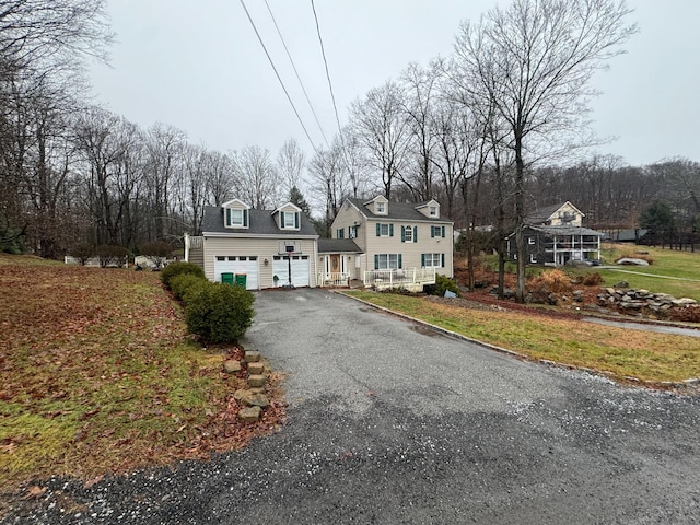 new england style home with a garage and a front yard