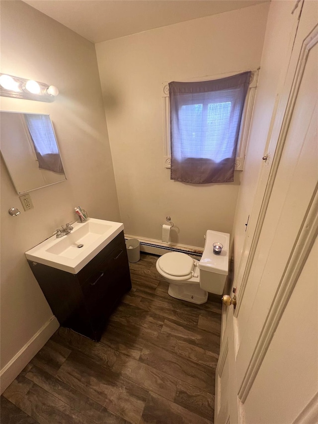 bathroom with hardwood / wood-style floors, vanity, a baseboard radiator, and toilet