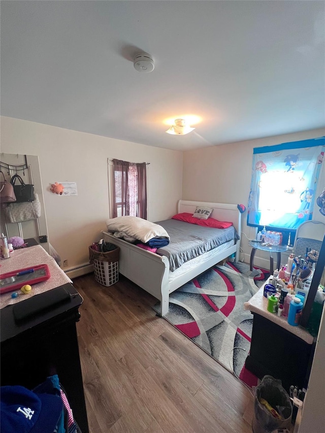 bedroom featuring hardwood / wood-style floors and baseboard heating