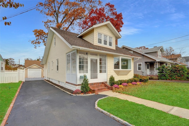 view of front of property featuring a front lawn, an outdoor structure, and a garage