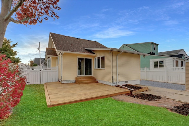 rear view of property with a yard and a wooden deck