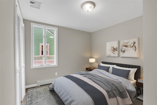 bedroom with light colored carpet and a baseboard radiator