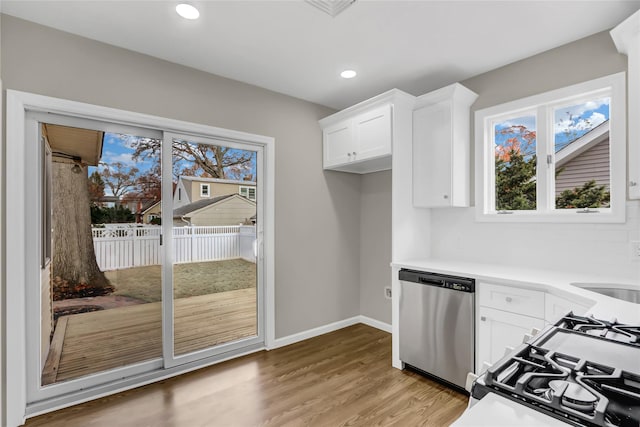 kitchen featuring hardwood / wood-style floors, dishwasher, sink, gas range, and white cabinetry