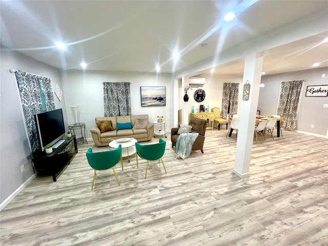 living room with light hardwood / wood-style flooring and a wall mounted air conditioner