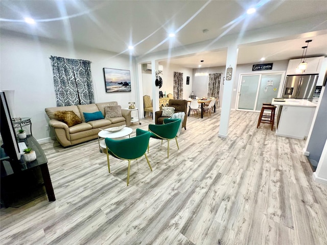 living room with light hardwood / wood-style flooring and an AC wall unit