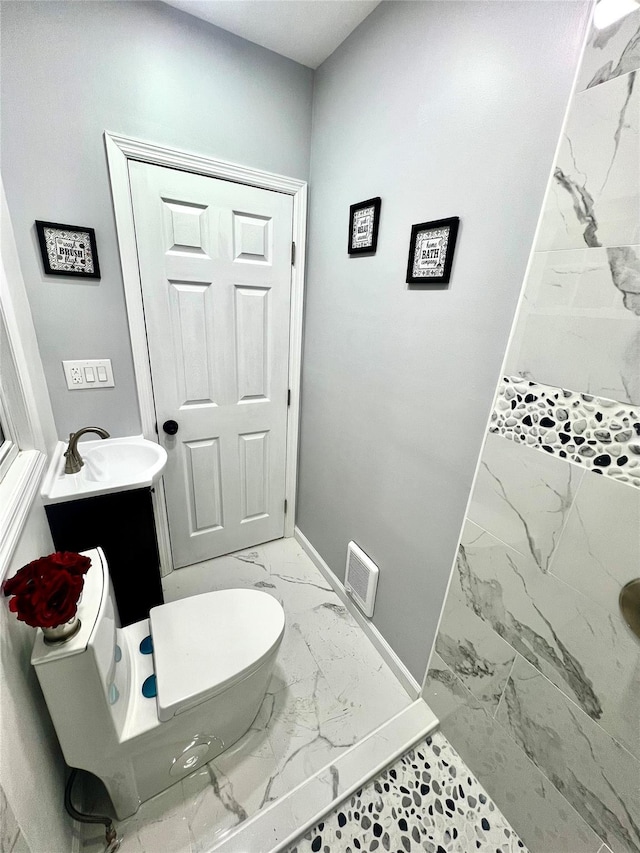 bathroom featuring vanity, toilet, and tiled shower