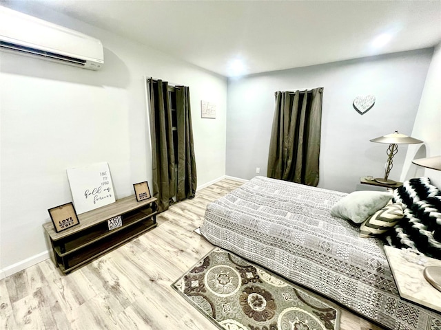 bedroom featuring hardwood / wood-style floors and an AC wall unit