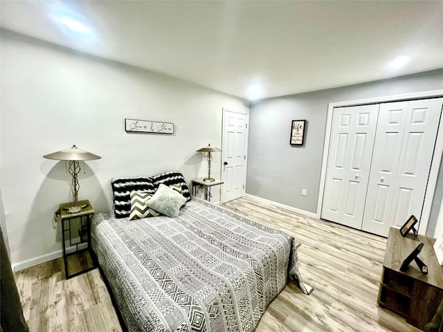 bedroom with light wood-type flooring and a closet