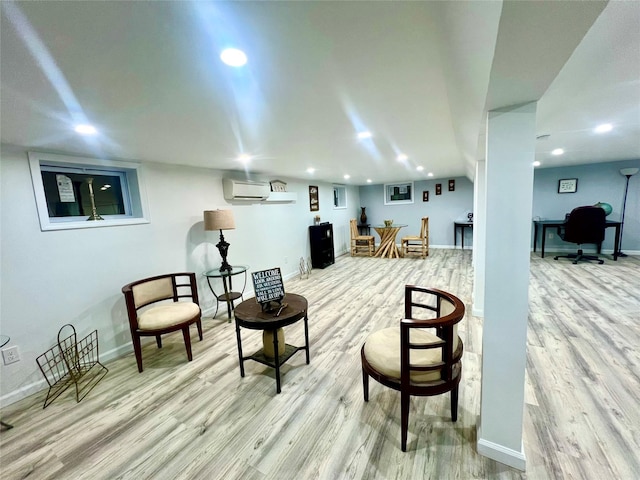 sitting room with a wall mounted AC and hardwood / wood-style flooring