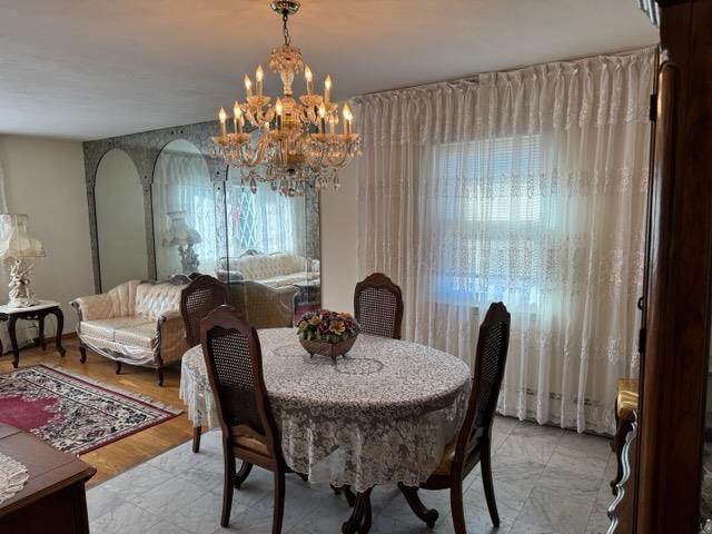 dining space featuring a notable chandelier and light wood-type flooring