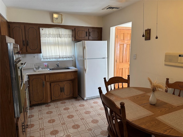 kitchen with sink, white fridge, and a wall mounted air conditioner