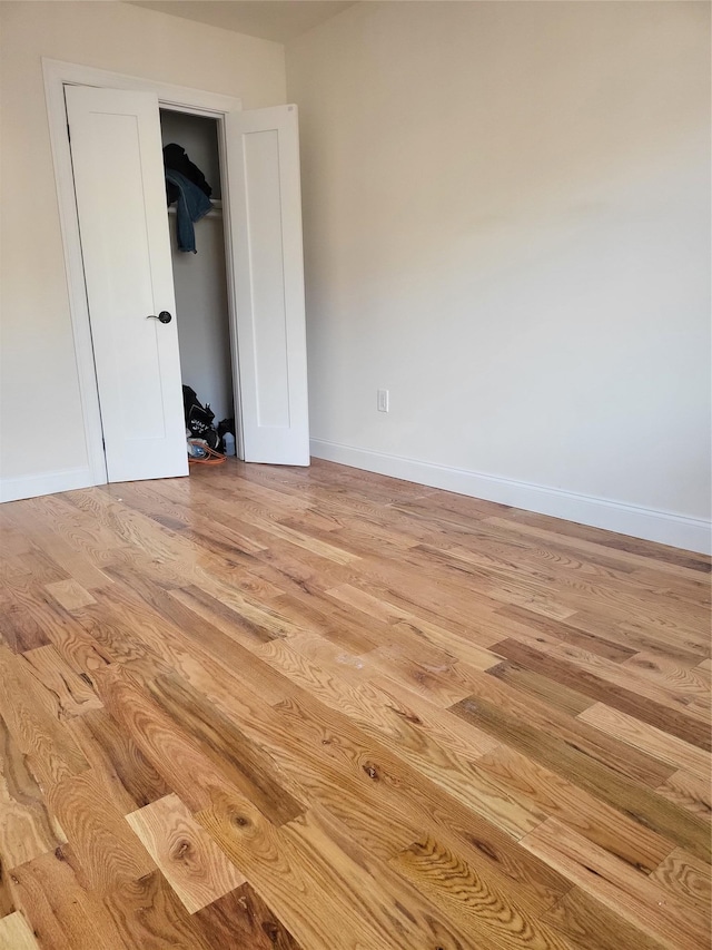 unfurnished bedroom featuring light hardwood / wood-style flooring and a closet