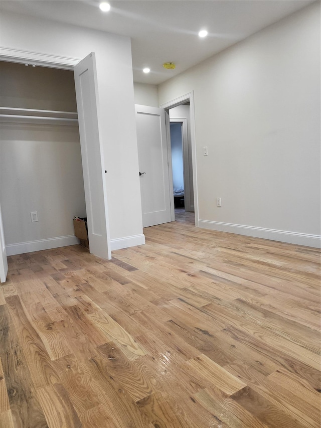 unfurnished bedroom with a closet and light hardwood / wood-style flooring