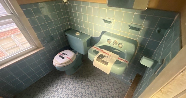 bathroom featuring tile walls and toilet