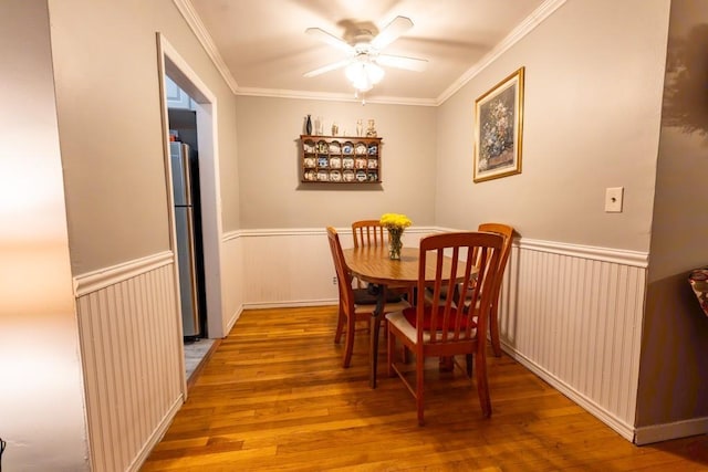 dining area with crown molding, ceiling fan, and wood-type flooring