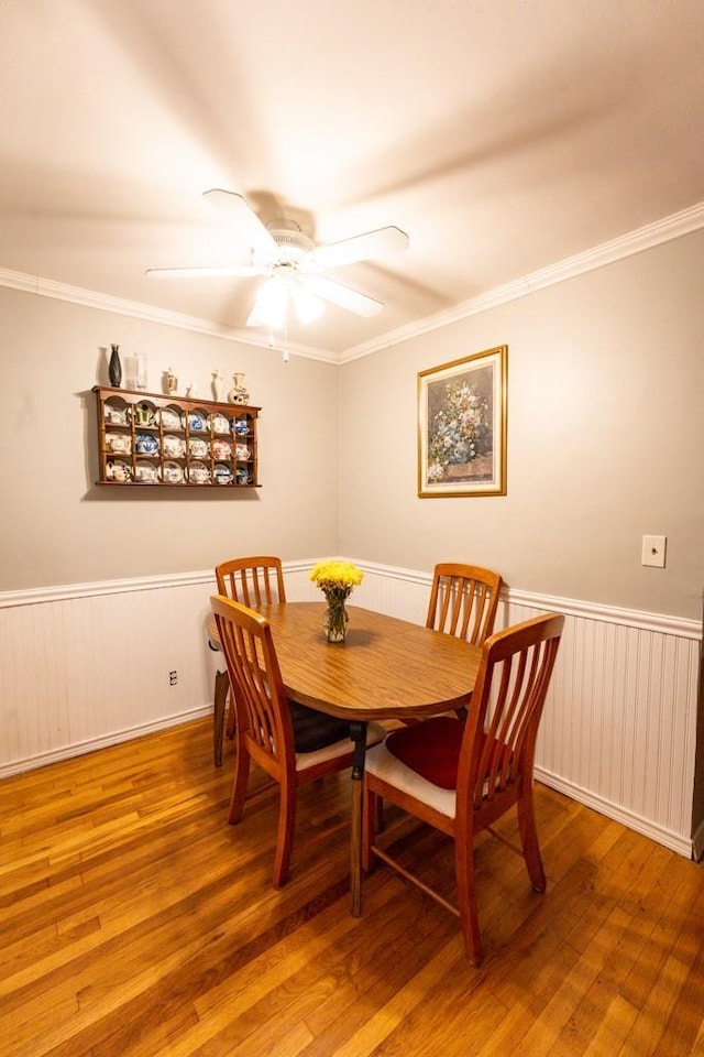 dining space with ceiling fan, hardwood / wood-style floors, and ornamental molding