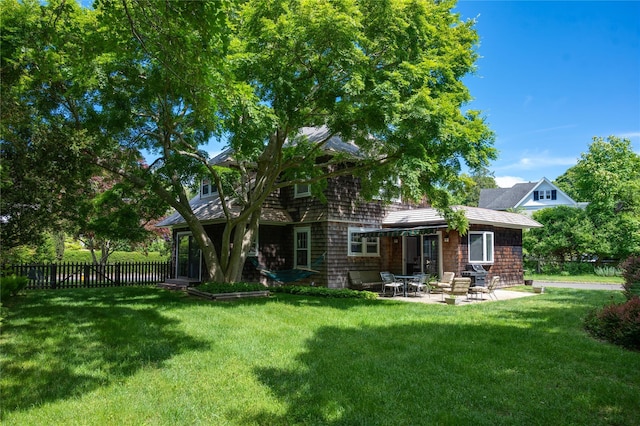 rear view of property with a lawn and a patio area