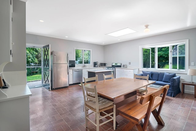 dining space featuring a skylight and sink