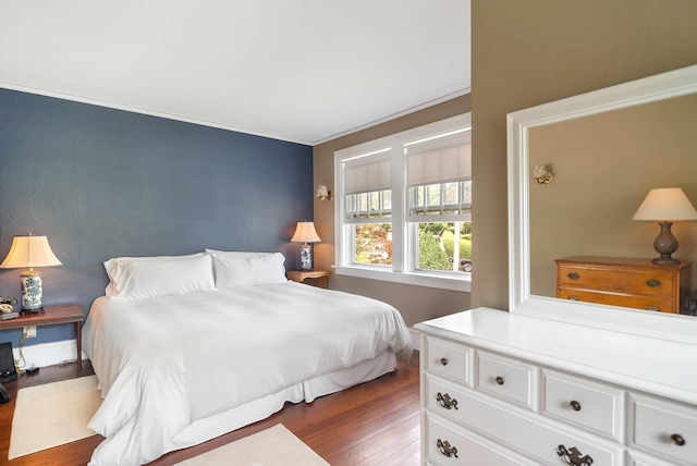 bedroom with crown molding and dark wood-type flooring