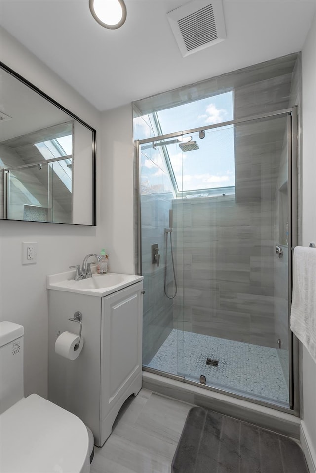 bathroom with a shower with door, vanity, and toilet