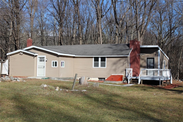 back of property with a deck and a lawn