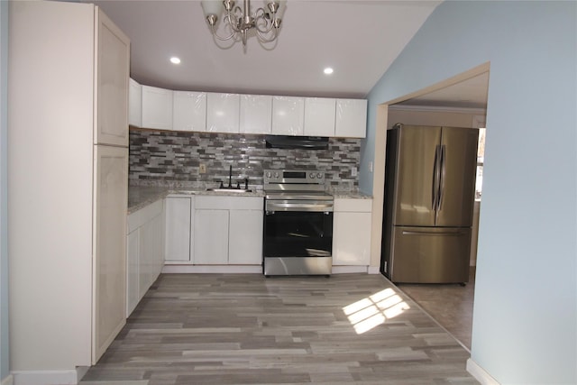 kitchen with decorative backsplash, stainless steel appliances, vaulted ceiling, sink, and white cabinets