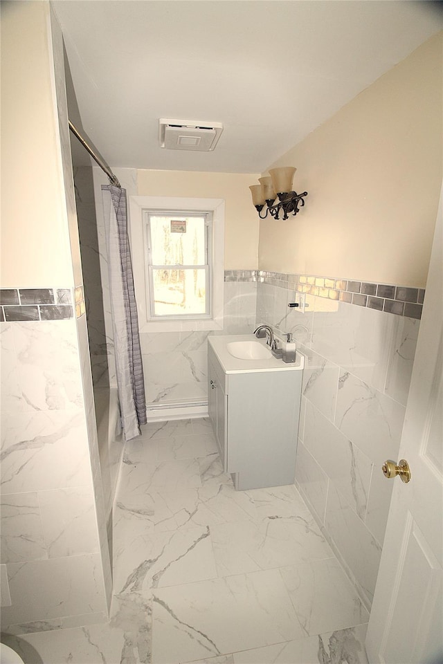 bathroom featuring vanity and tile walls