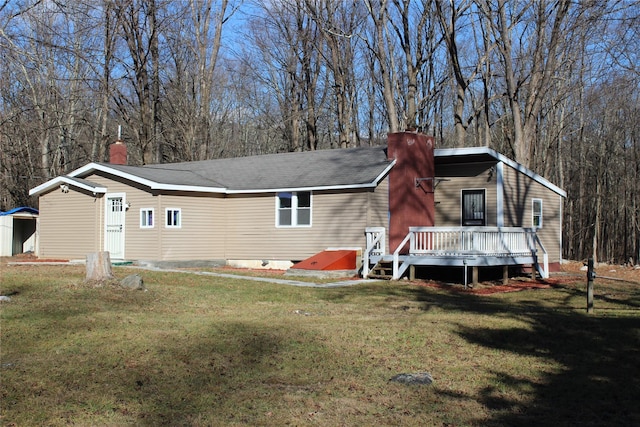 rear view of property featuring a deck and a yard