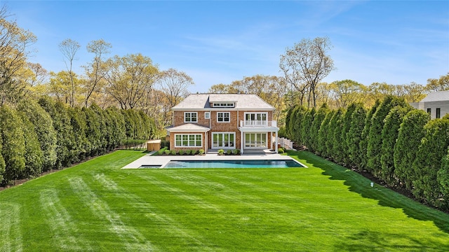 back of property featuring a yard, a balcony, and a patio