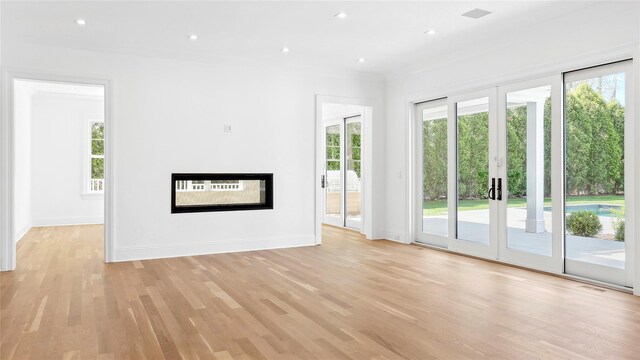 unfurnished living room with a healthy amount of sunlight and light hardwood / wood-style floors