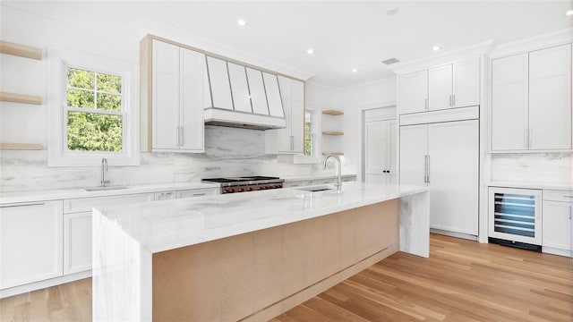 kitchen featuring paneled refrigerator, white cabinetry, and sink