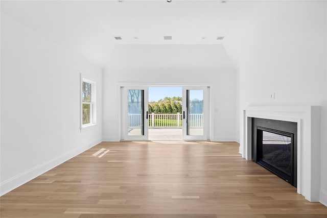 unfurnished living room with light hardwood / wood-style flooring and lofted ceiling