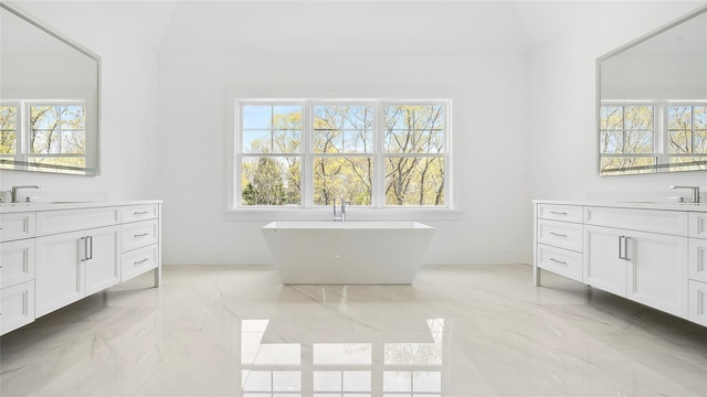 bathroom featuring vanity, lofted ceiling, and a tub