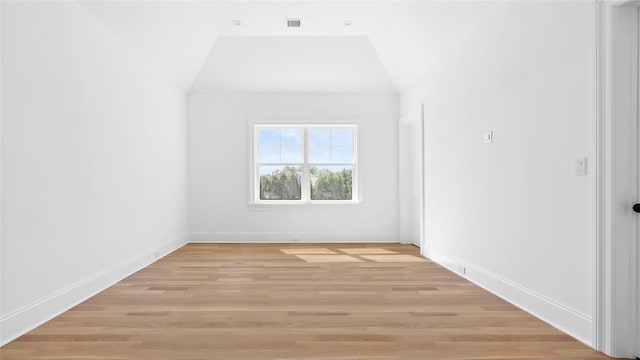 unfurnished room featuring light hardwood / wood-style flooring and lofted ceiling