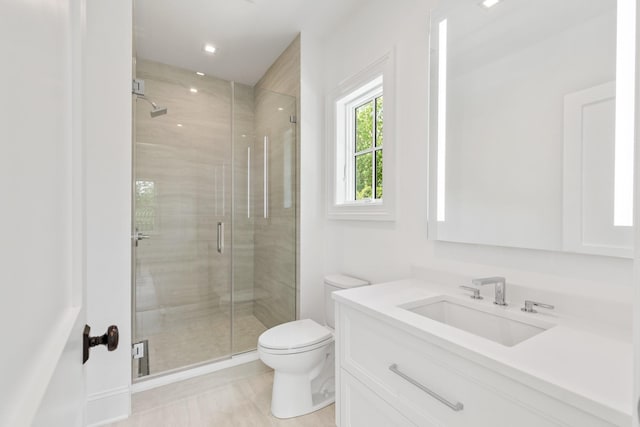 bathroom with vanity, an enclosed shower, and toilet