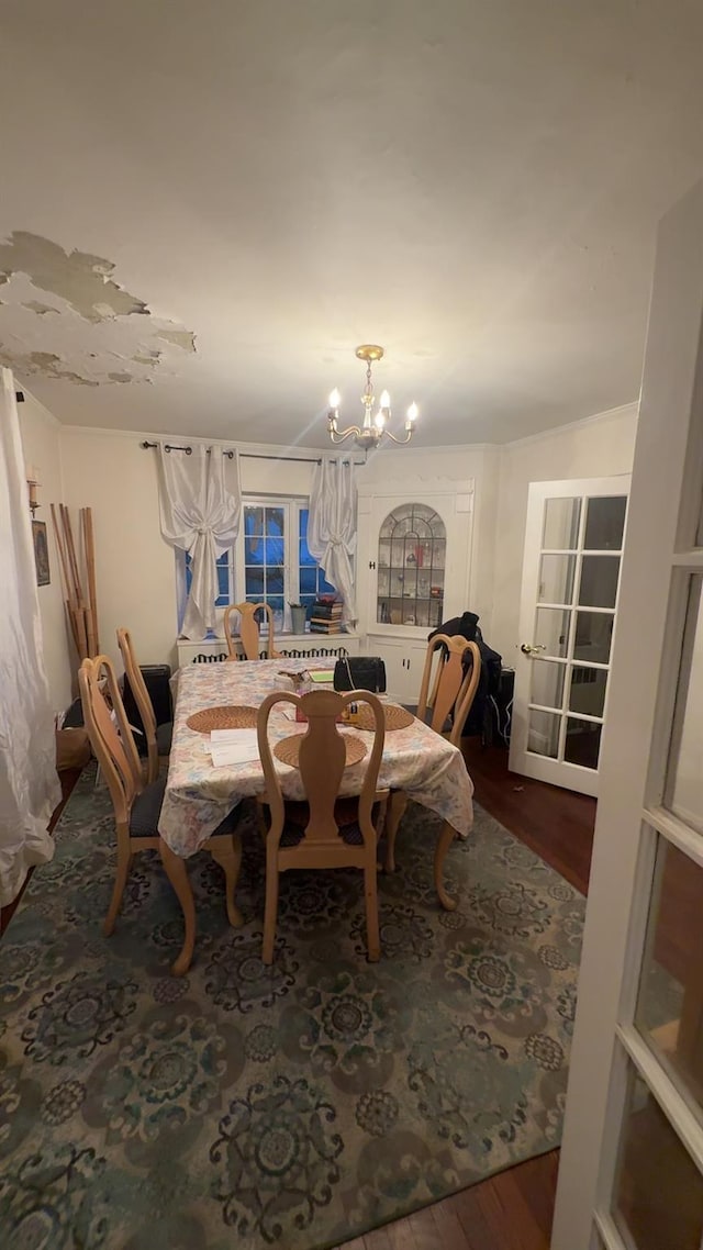 dining space featuring wood-type flooring and a chandelier