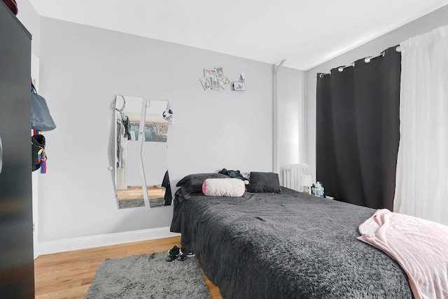 bedroom with radiator and wood-type flooring