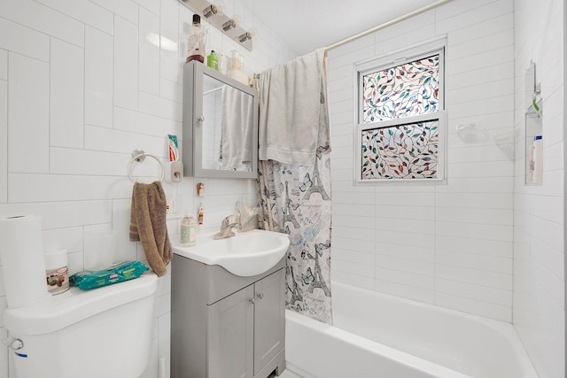 full bathroom featuring vanity, toilet, shower / bathtub combination with curtain, and tile walls