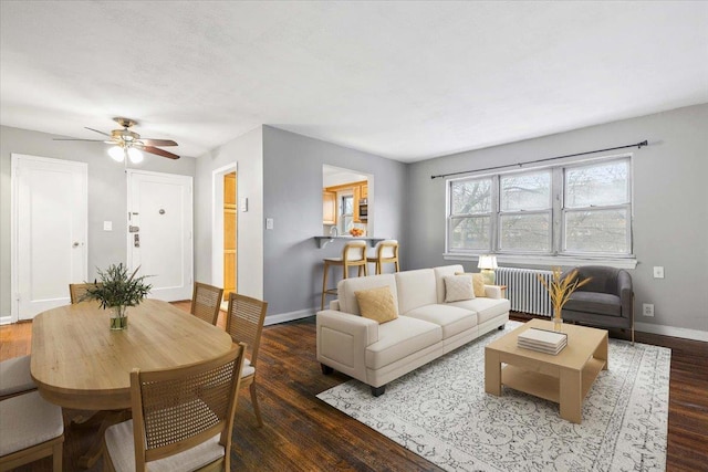 living room with ceiling fan, dark hardwood / wood-style flooring, and radiator heating unit