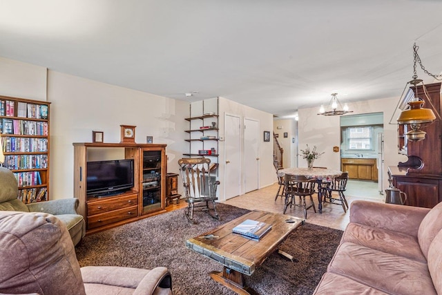 carpeted living room with an inviting chandelier