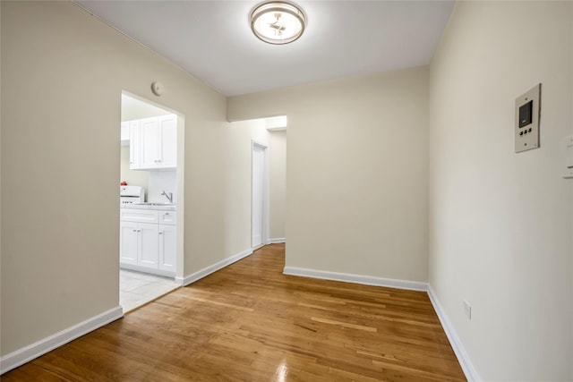 hall with light wood-type flooring and sink