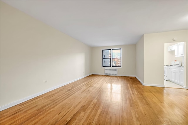 empty room featuring light hardwood / wood-style flooring and radiator