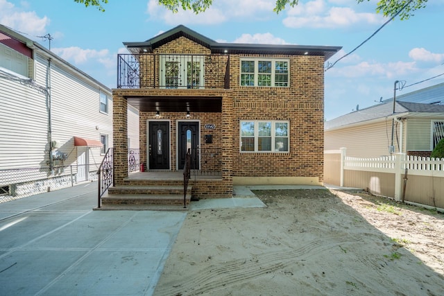 115-42 Inwood St, Jamaica, NY 11436 - view of front facade featuring a balcony and brick siding