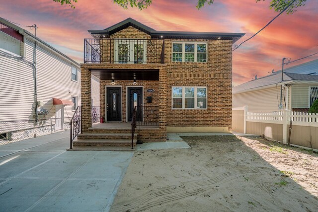 115-42 Inwood St, Jamaica, NY 11436 - back of property at dusk with a balcony and brick siding