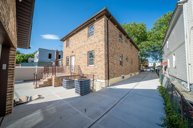 115-42 Inwood St, Jamaica, NY 11436 - rear view of house with central AC, brick siding, and a patio