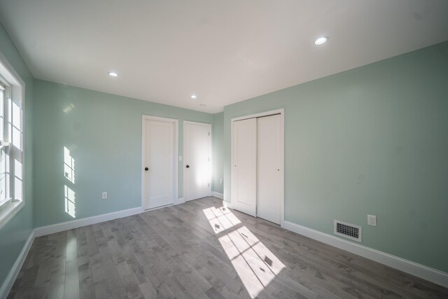 115-42 Inwood St, Jamaica, NY 11436 - unfurnished bedroom featuring wood finished floors, baseboards, multiple windows, and recessed lighting