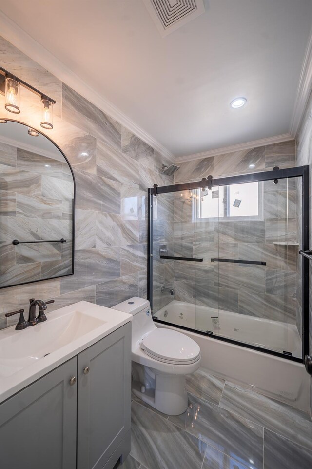 115-42 Inwood St, Jamaica, NY 11436 - full bath featuring ornamental molding, bath / shower combo with glass door, toilet, tile walls, and vanity